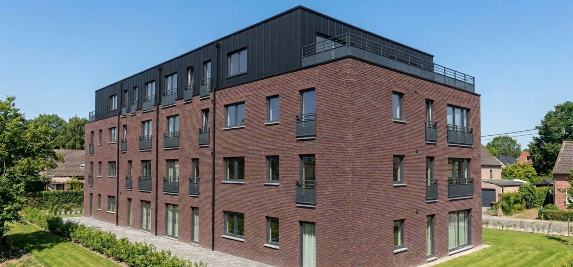 L'angle du bâtiment, façade en brique et dernier étage en zinc